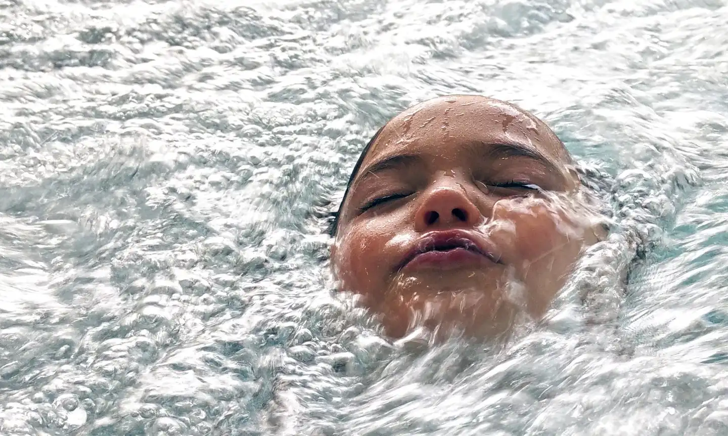 Imagen de una persona nadando con el rostro bajo el agua para ilustrar por qué los ojos se ven rojos debajo del agua.
