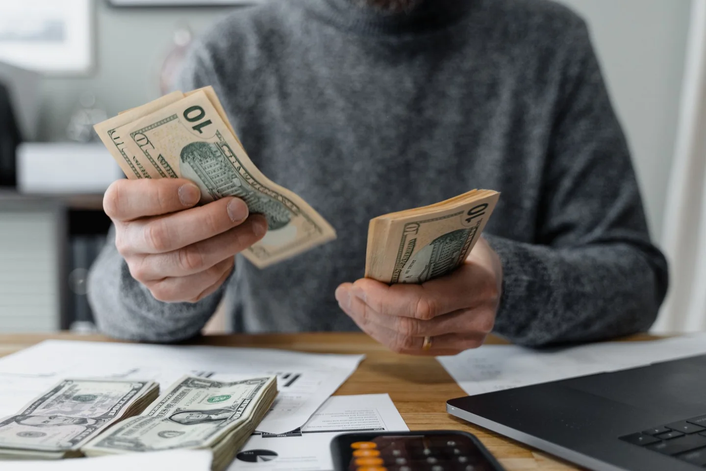 Traveler counting cash para ilustrar por qué pagar en efectivo vuelve en los viajes.