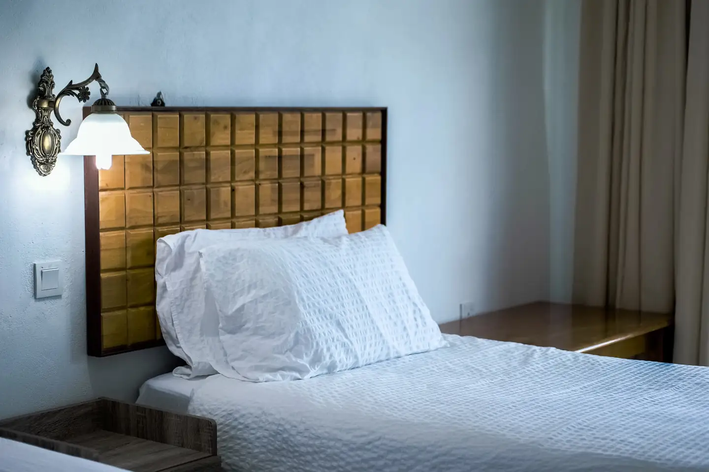 Cama de hotel blanca para ilustrar por qué las sábanas de los hoteles son blancas