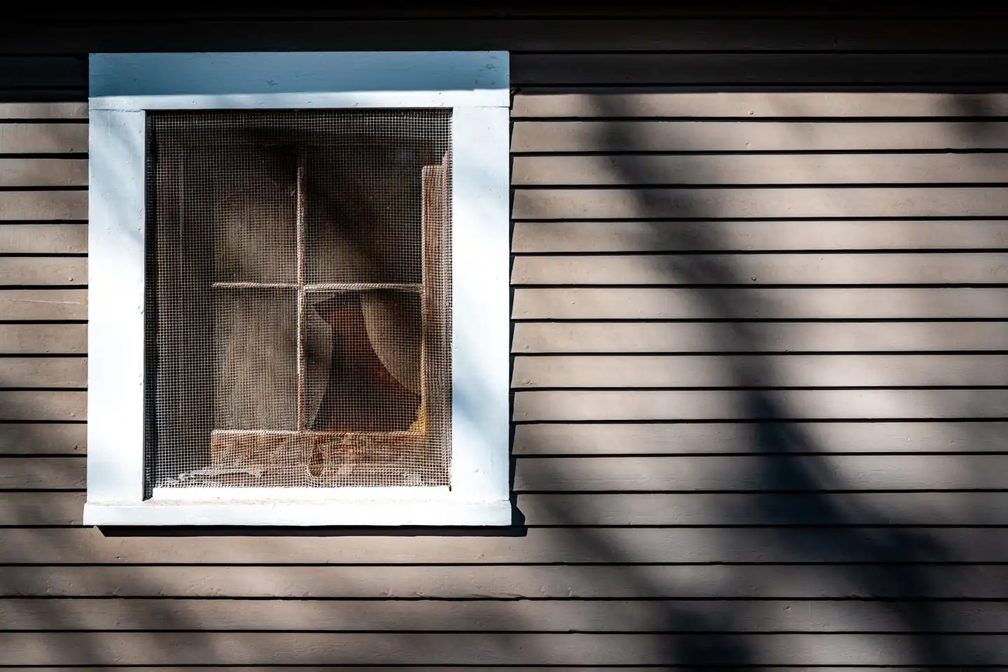 Mosquiteras sin taladrar para ventanas instaladas en una ventana de casa, mostrando una solución práctica para ventilar sin insectos.