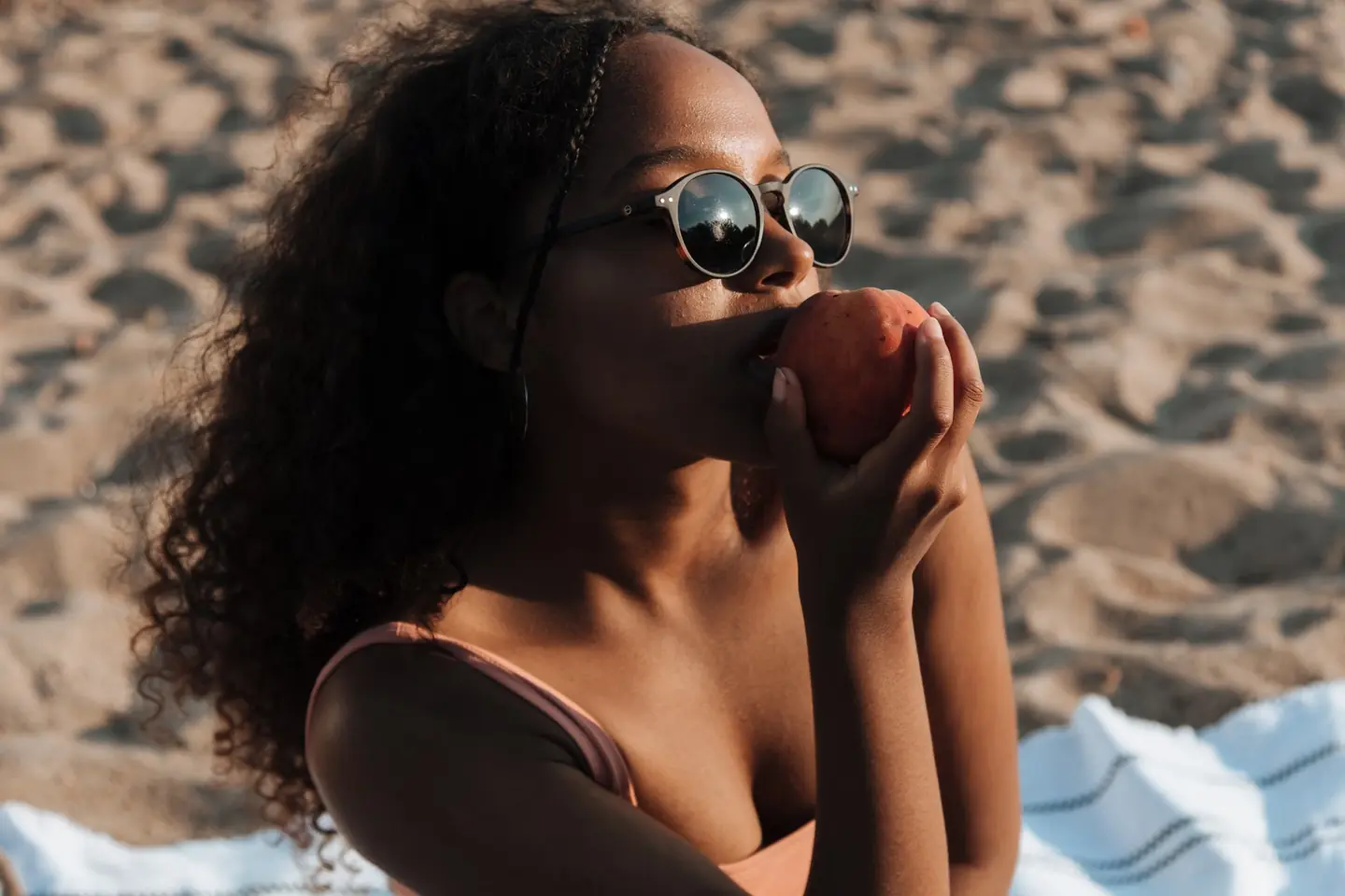 Mujer comiendo en la playa para ilustrar por qué el mar da hambre