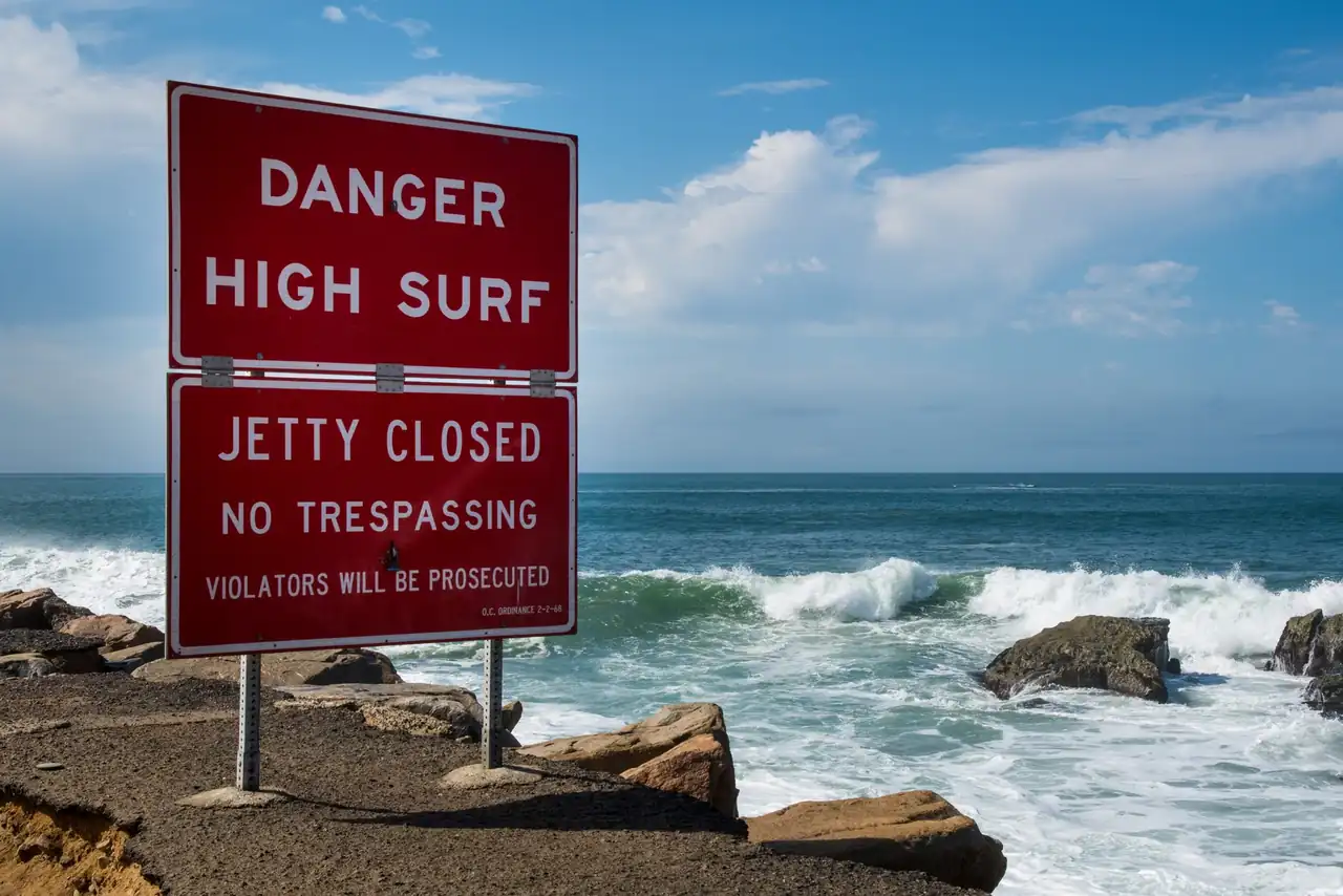 Cartel de playa cerrada por contaminación junto al mar