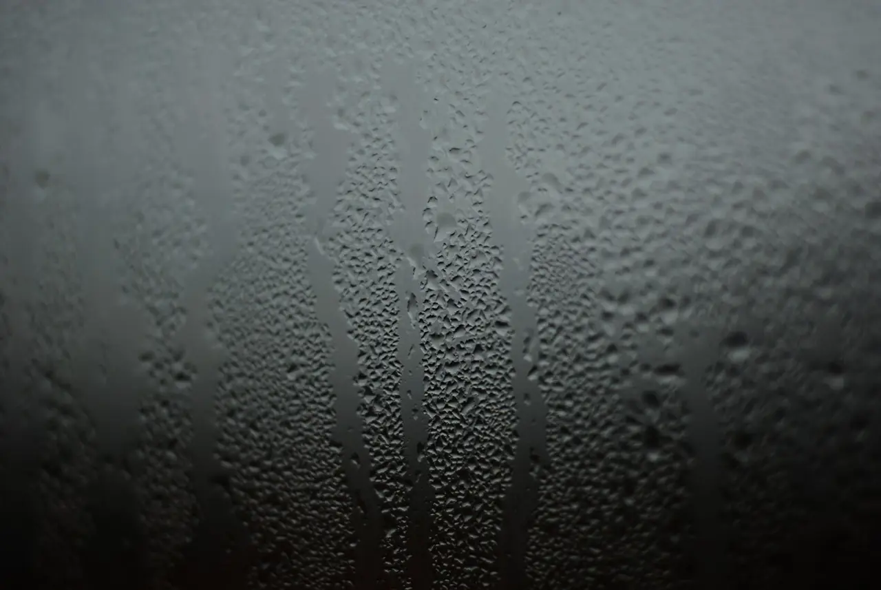 Vaso frío suda y muestra gotas de condensación en un ambiente húmedo