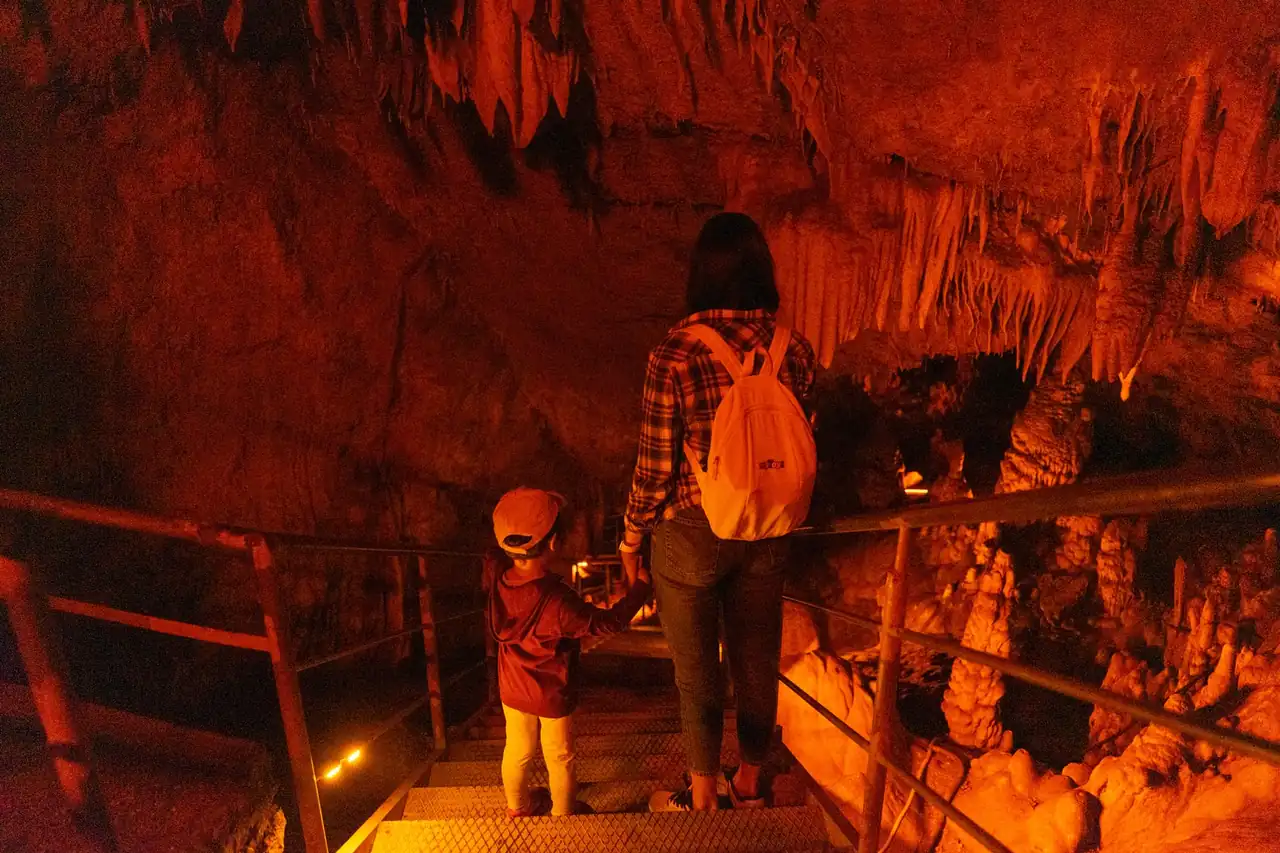 Visitantes recorriendo cuevas turísticas frescas de España durante una escapada de verano