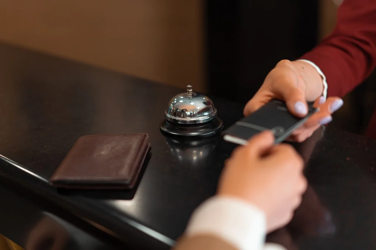 Huésped realizando el pago y gestionando el depósito del hotel con tarjeta en recepción