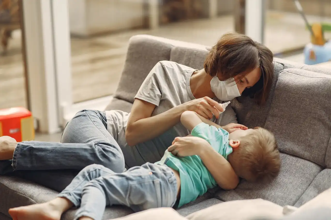 Madre ofreciendo una solución de rehidratación a un niño con deshidratación infantil