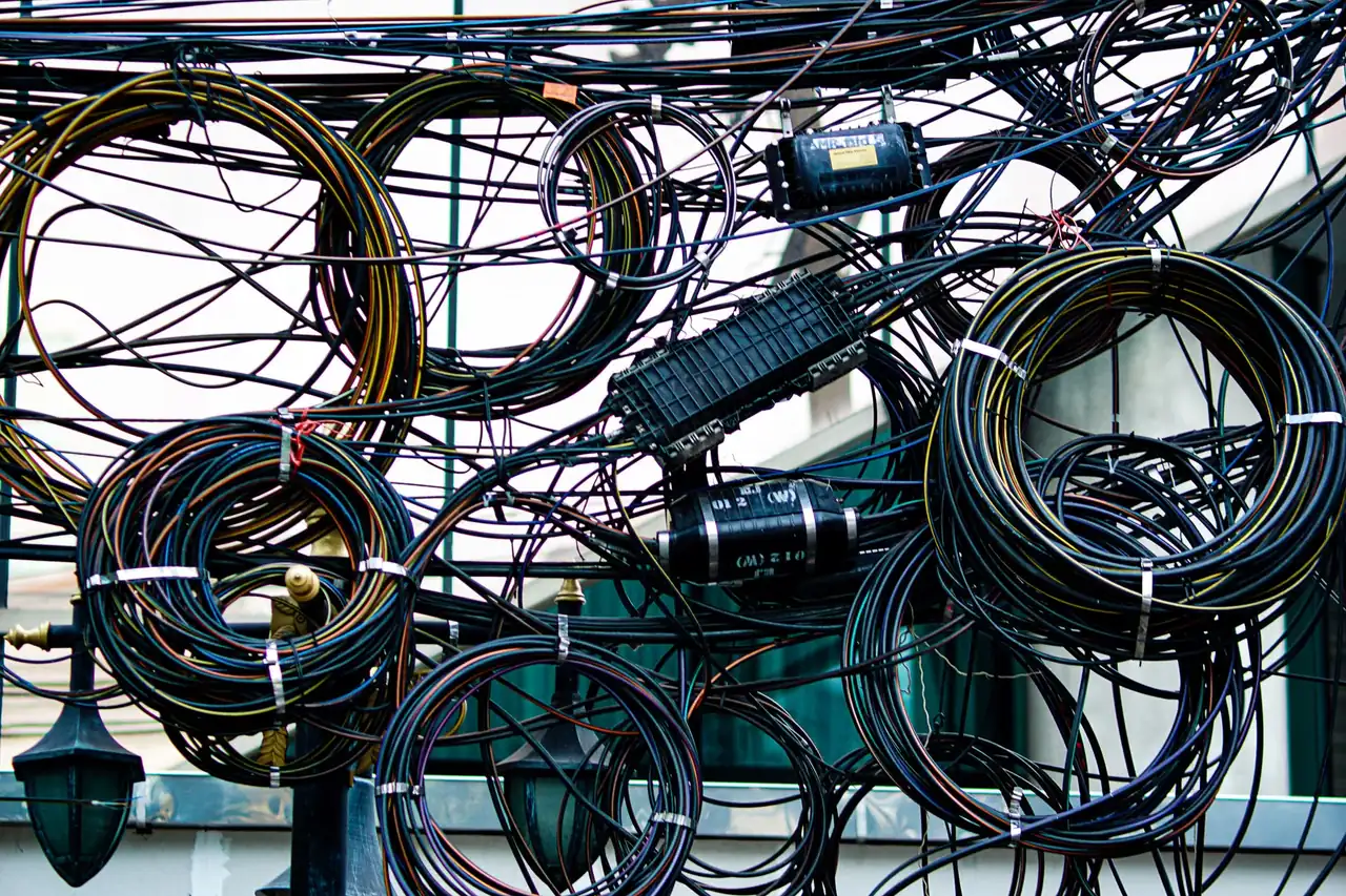 Regleta eléctrica caliente sobre un escritorio, con cables y señales visibles de sobrecalentamiento