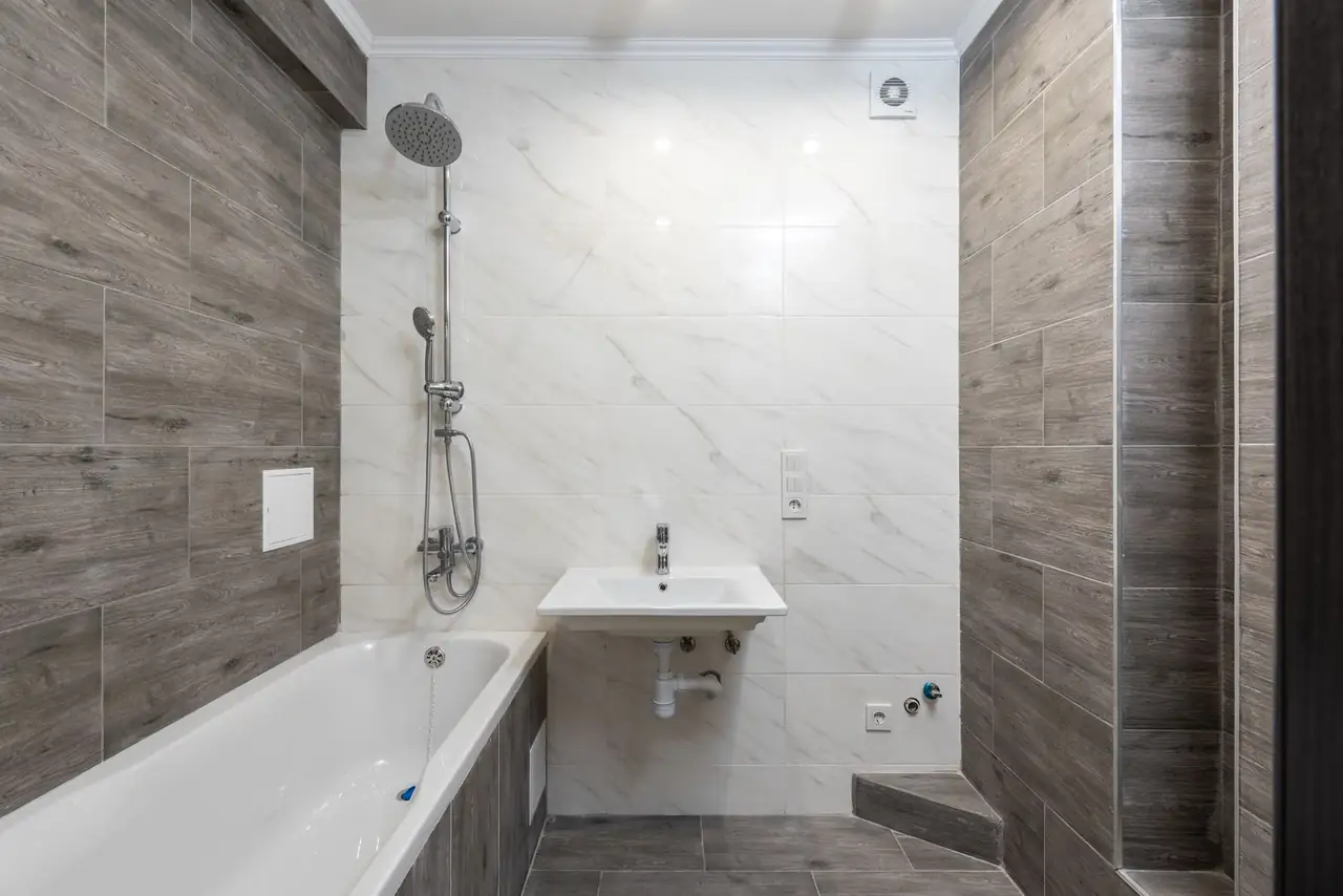 Moscas del desagüe del baño sobre un lavabo y azulejos