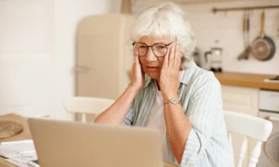anciana preocupada delante portatil