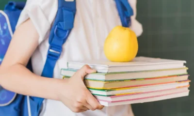 chico lleva manzana con libros