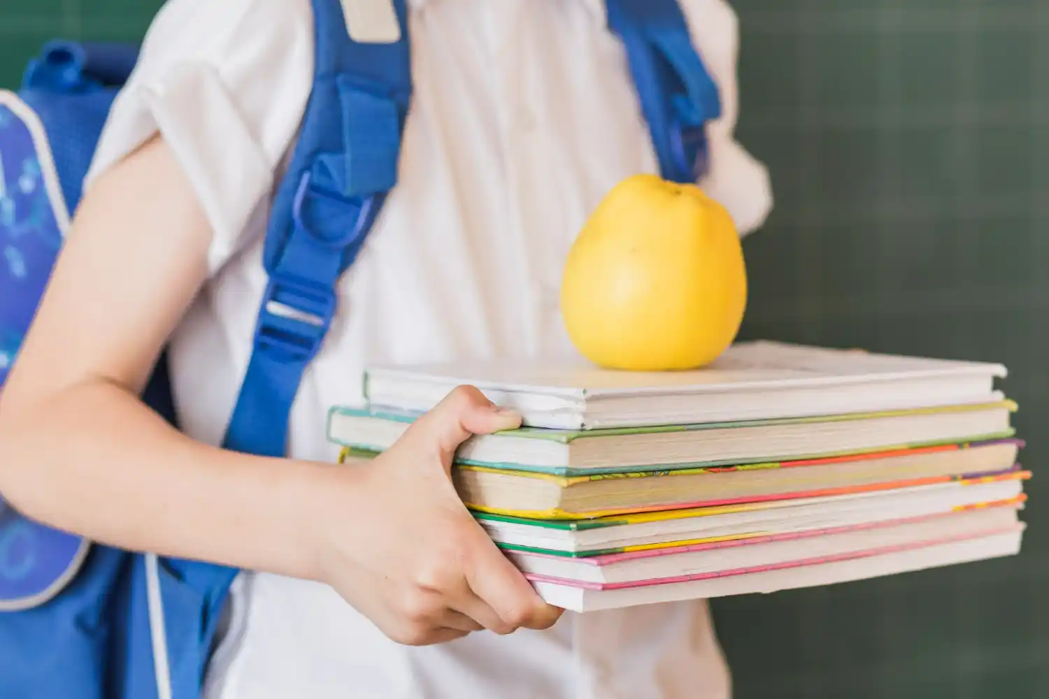 chico lleva manzana con libros