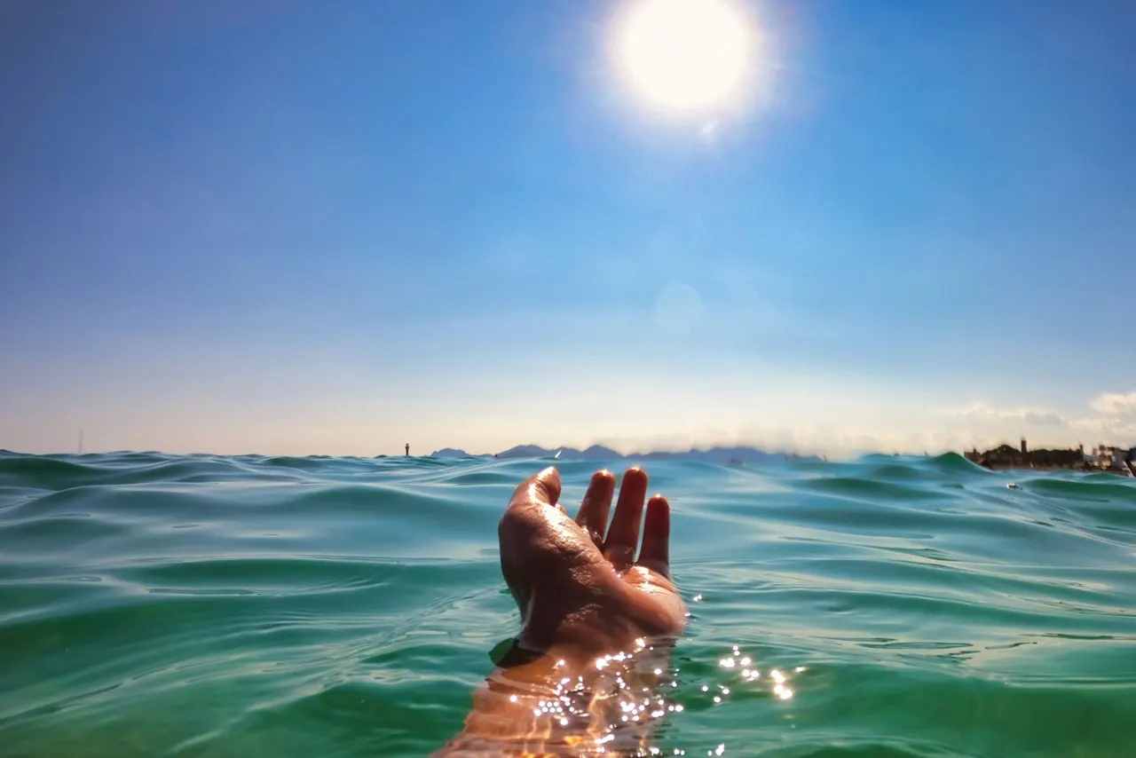 mano nel mar bajo el sol