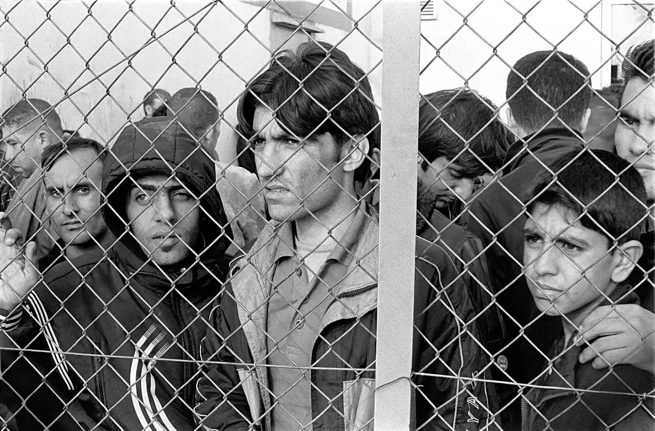 migrantes e una valla
