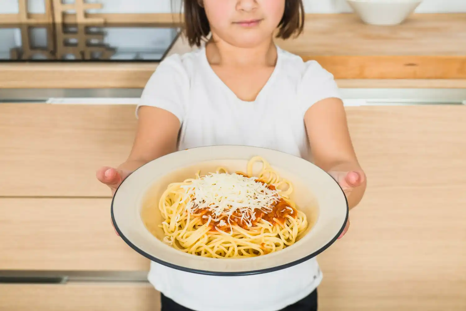 niña sujeta plato de pasta