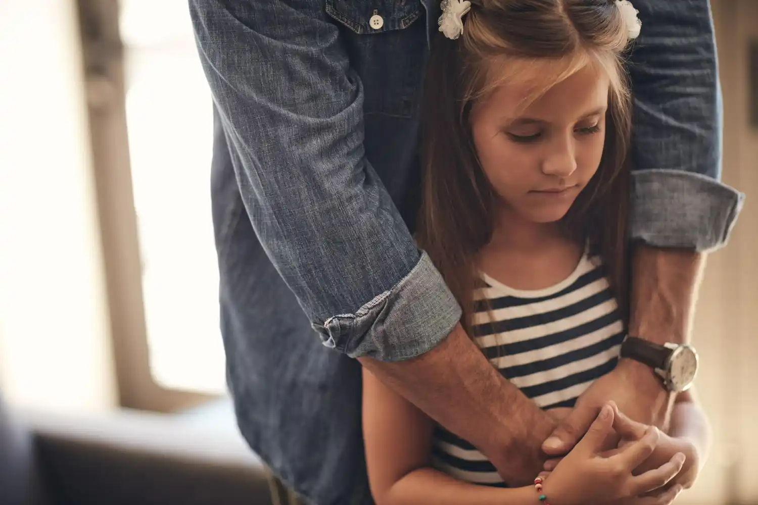 padre tiene hija con sus brazos