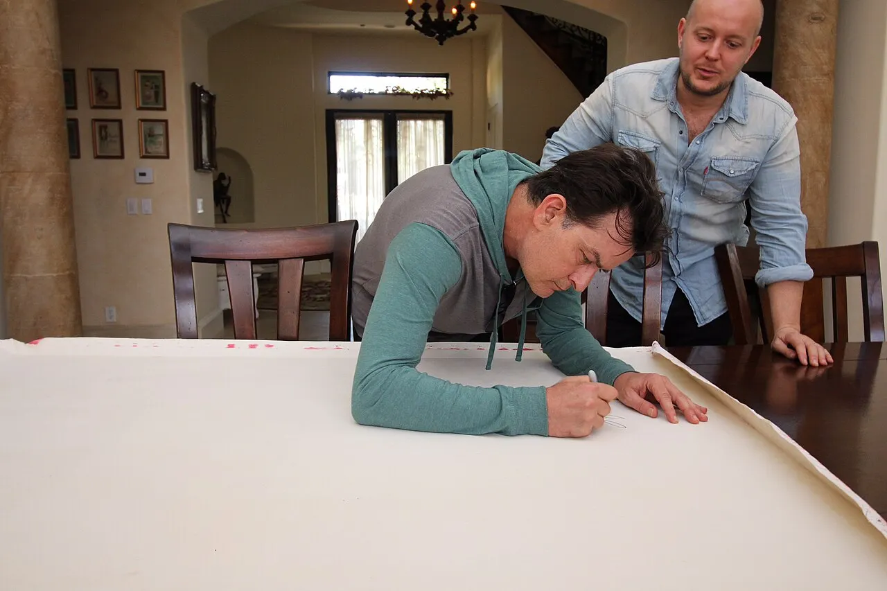 Charlie Sheen firmando un retrato