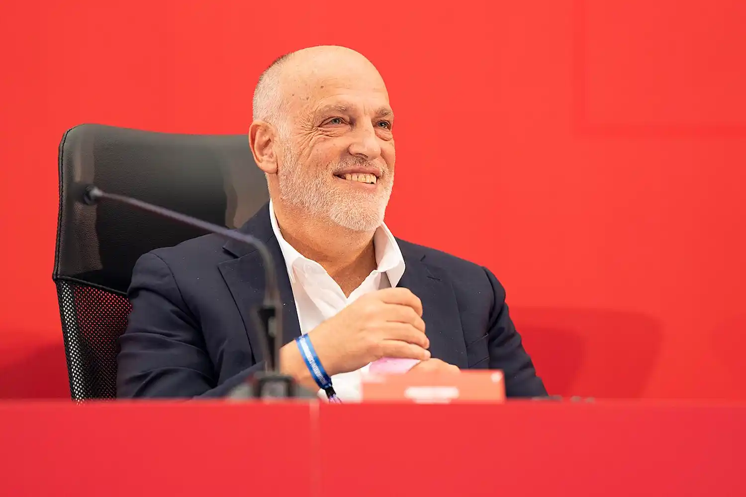 Javier Tebas sonrie fondo rojo