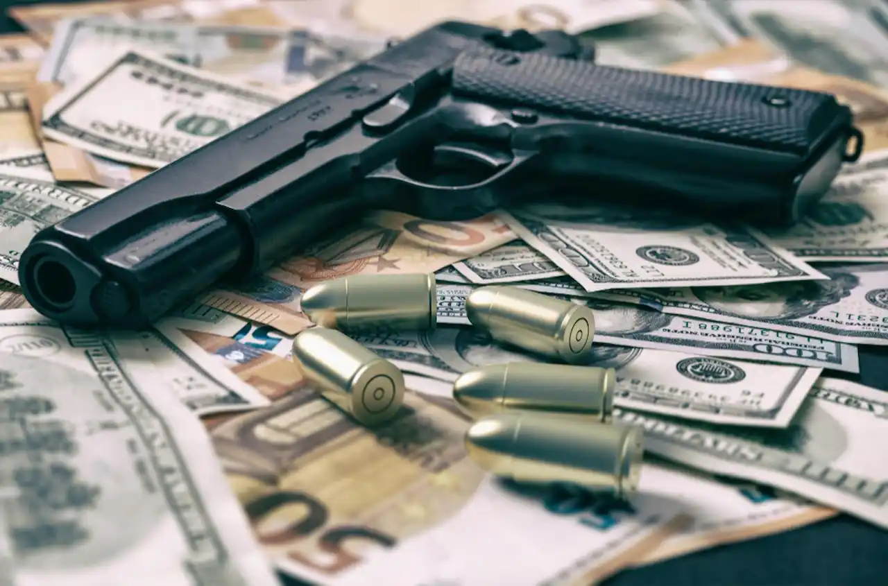 arma sobre dinero y balas