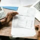 Documentos bancarios y calculadora para revisar las condiciones al cancelar depósito antes de vencimiento
