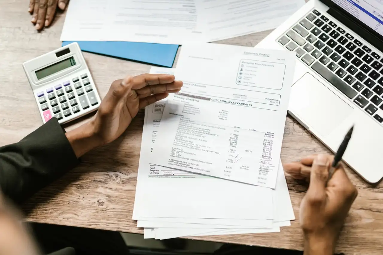 Documentos bancarios y calculadora para revisar las condiciones al cancelar depósito antes de vencimiento