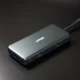 Cargador GaN compacto junto a un móvil y un portátil