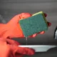 Filtro del lavavajillas desmontado para limpiarlo bajo el grifo