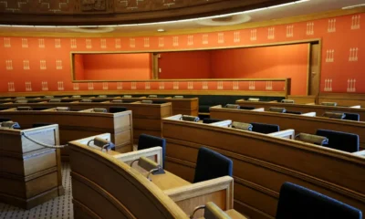 Sala preparada para una Comisión de investigación parlamentaria, con micrófonos y documentos sobre las mesas