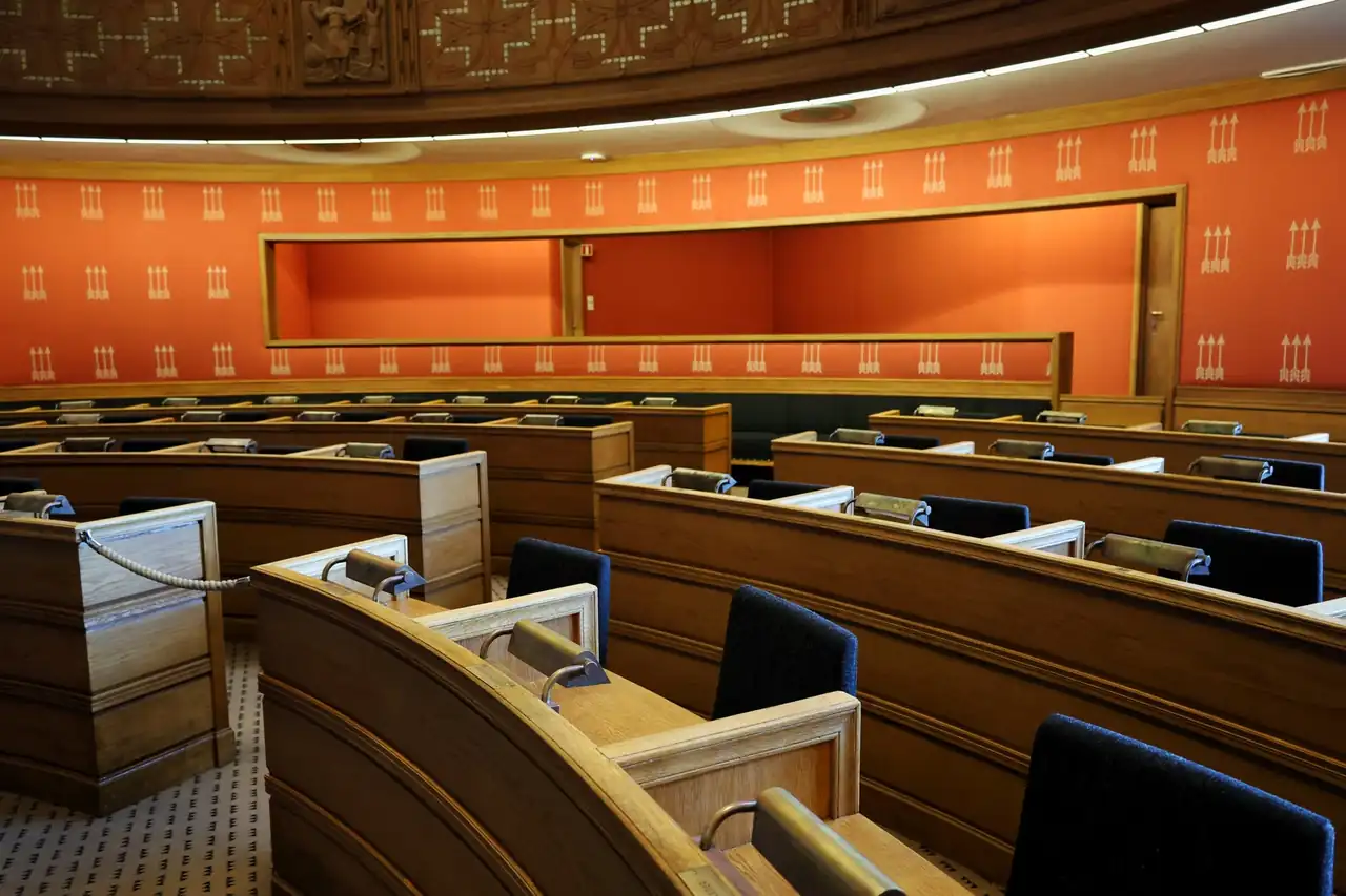 Sala preparada para una Comisión de investigación parlamentaria, con micrófonos y documentos sobre las mesas