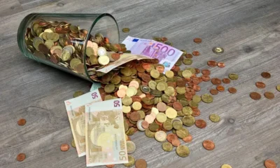 Hucha con monedas y billetes para ilustrar la decisión de ahorrar o invertir con tipos altos