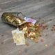 Hucha con monedas y billetes para ilustrar la decisión de ahorrar o invertir con tipos altos