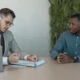 Candidatura y entrevistador conversan sobre cómo negociar el sueldo en una entrevista de trabajo