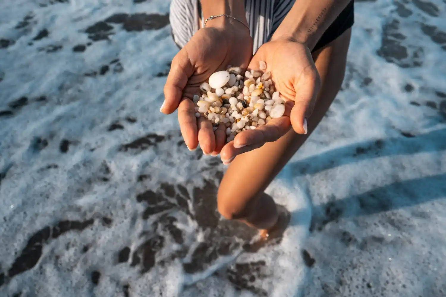 manos con conchas en la playa