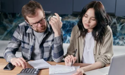 Persona que calcula el coste real de un préstamo rápido con los documentos y una calculadora