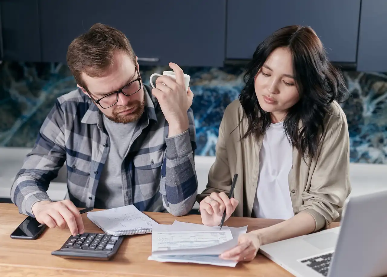 Persona que calcula el coste real de un préstamo rápido con los documentos y una calculadora