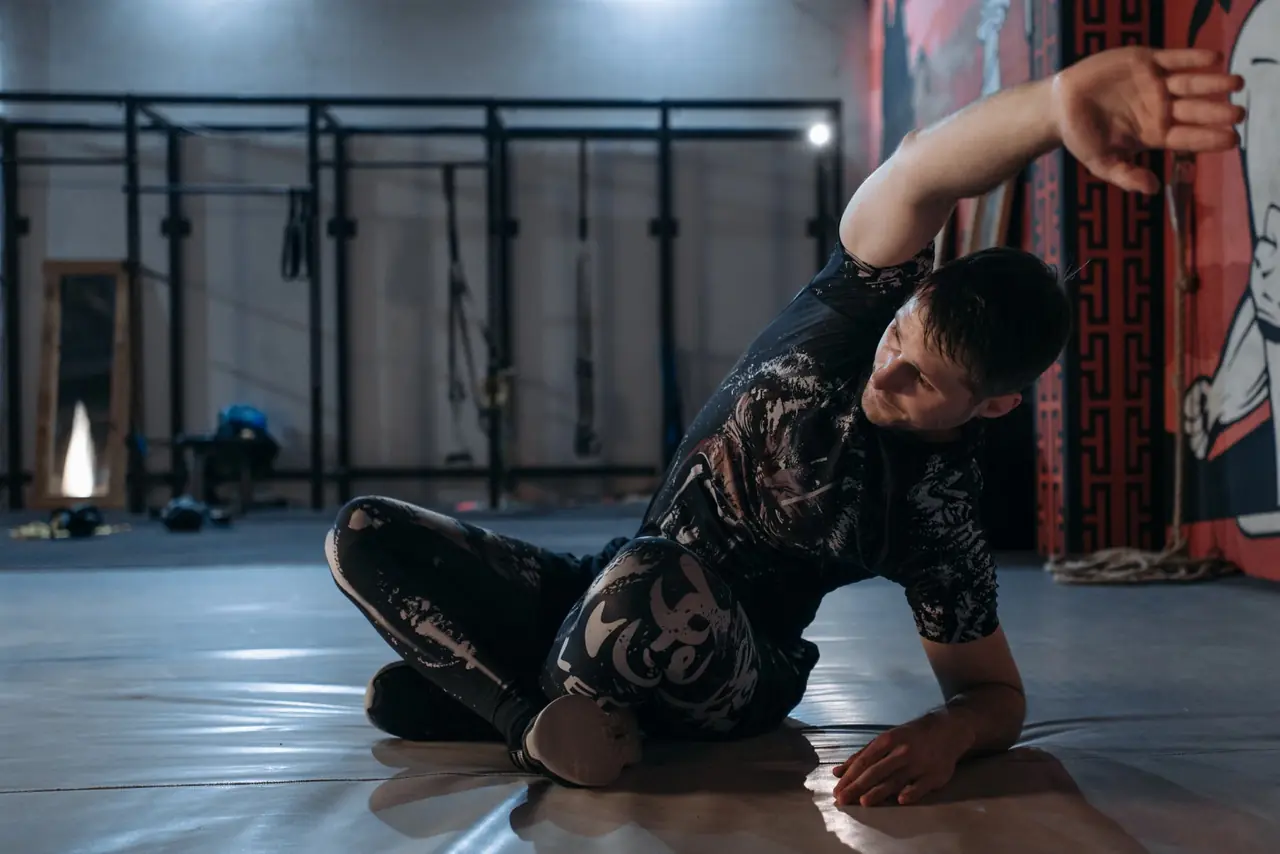 Persona calentando en el gimnasio antes de volver a entrenar tras vacaciones