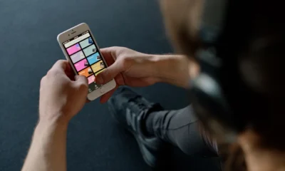 Móvil con una aplicación de música, donde la letra E de Explicit en Spotify identifica canciones señaladas como explícitas