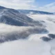Valle cubierto de niebla durante una inversión térmica, visto desde una ladera soleada