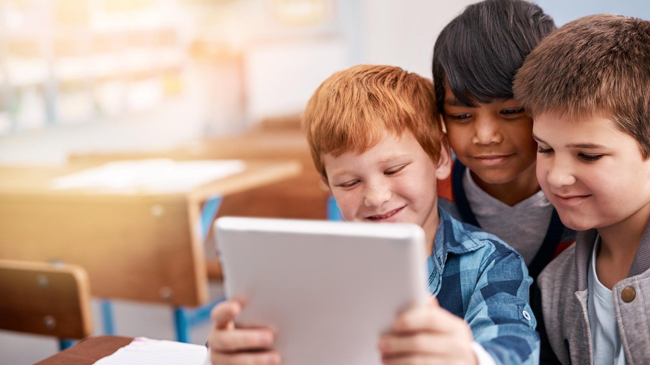 Niños usando tabletas en el aula de un colegio