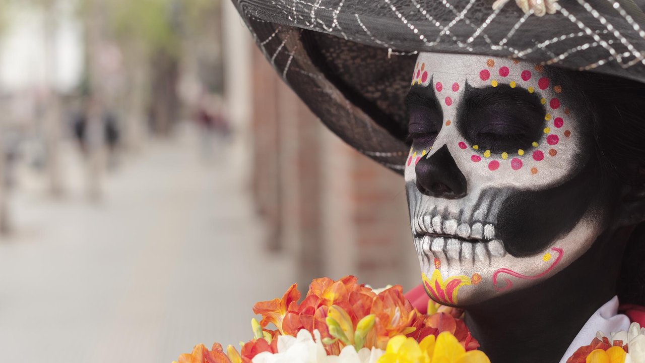 Altar de Día de Muertos con flores de cempasúchil, velas y calaveras de azúcar