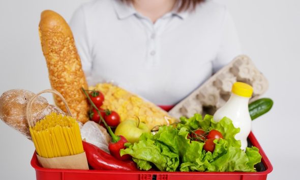 Cesta de la compra llena de productos en un supermercado español, afectado por la subida de precios de los alimentos