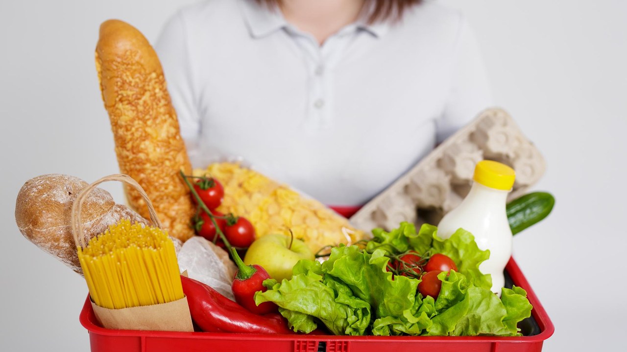 Cesta de la compra llena de productos en un supermercado español, afectado por la subida de precios de los alimentos