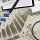 Billetes de euros y calculadora, concepto de deuda e intereses