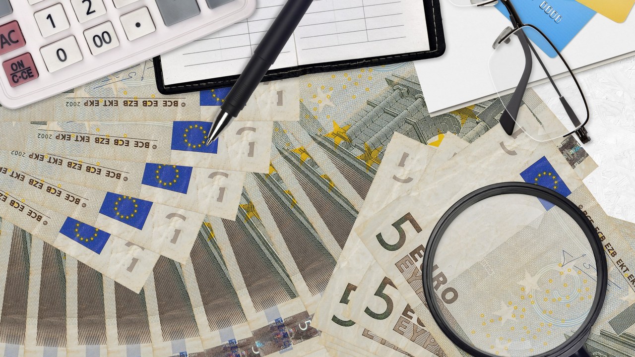 Billetes de euros y calculadora, concepto de deuda e intereses