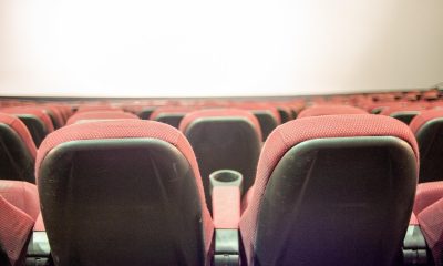 Sala de cine con butacas rojas y pantalla iluminada