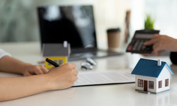 Firma de un préstamo hipotecario con una familia y un asesor bancario