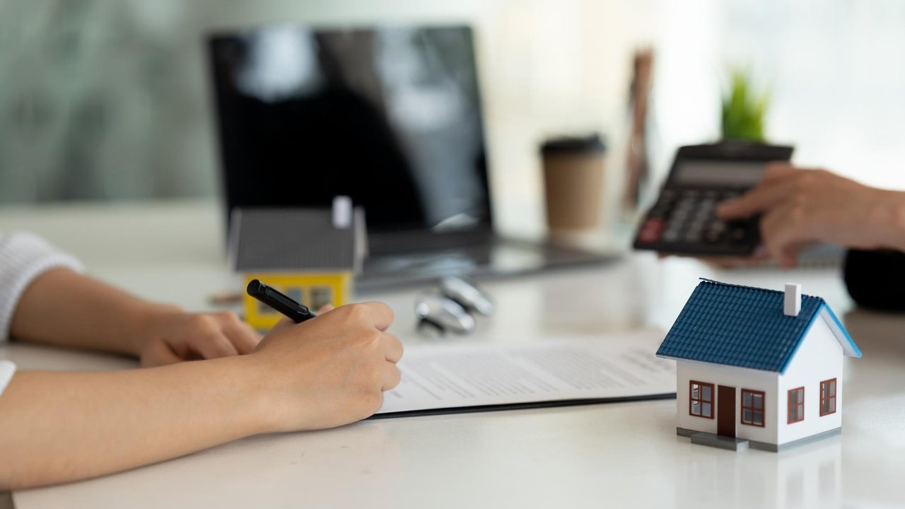 Firma de un préstamo hipotecario con una familia y un asesor bancario