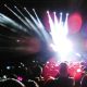 Gente disfrutando de un concierto multitudinario con luces de escenario