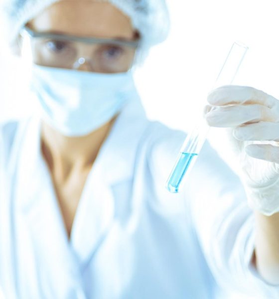 Científica investigando tubos con reactivos en un laboratorio