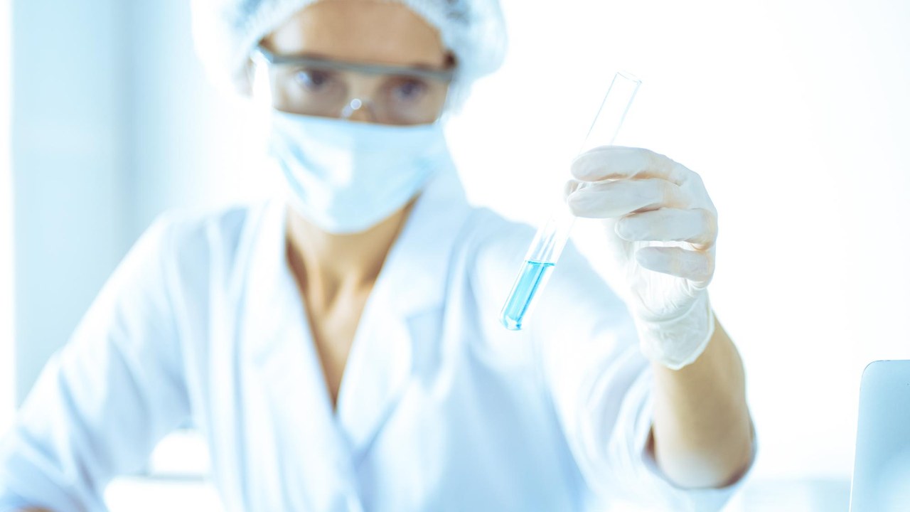 Científica investigando tubos con reactivos en un laboratorio