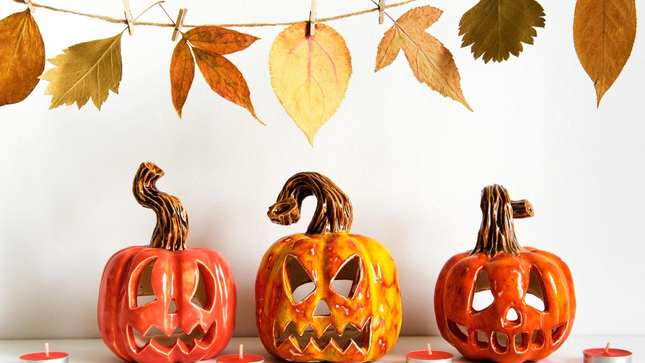 Calabazas talladas iluminadas con velas en una decoración de Halloween de otoño